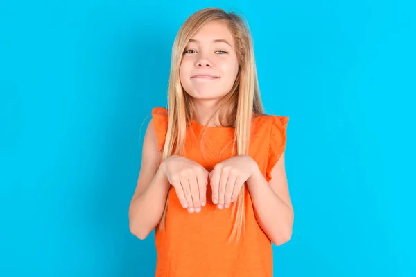 Κοριτσάκι Φορώντας Πορτοκαλί Shirt Πάνω Από Μπλε Φόντο Κάνει Λαγουδάκι — Φωτογραφία Αρχείου