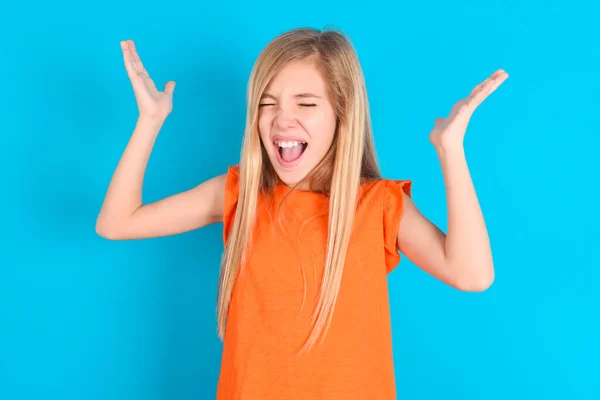 Mała Dziewczynka Nosi Pomarańczowy Shirt Niebieskim Tle Szaleje Jak Głowa — Zdjęcie stockowe