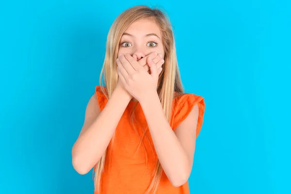 Niña Aturdida Con Camiseta Naranja Sobre Fondo Azul Cubre Ambas — Foto de Stock