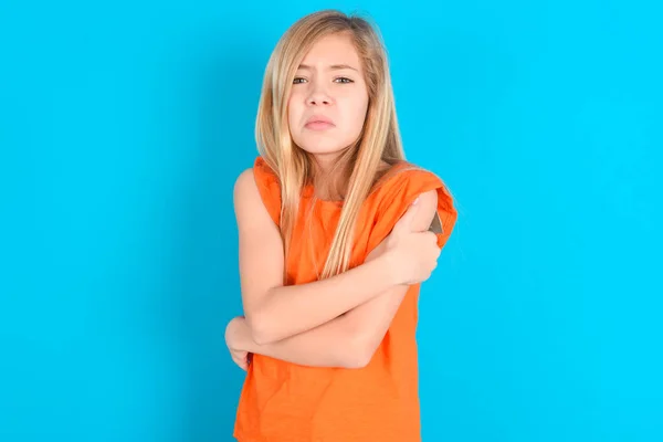 Klein Kind Meisje Dragen Oranje Shirt Blauwe Achtergrond Schudden Bevriezen — Stockfoto