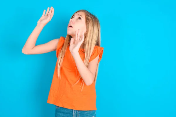 Bambina Che Indossa Arancione Shirt Sfondo Blu Mantiene Palmi Delle — Foto Stock