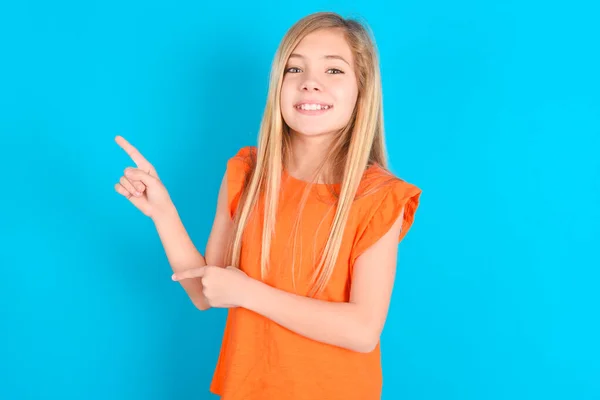 Klein Meisje Dragen Oranje Shirt Blauwe Achtergrond Punten Kopieerruimte Geeft — Stockfoto