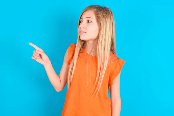 Little Kid Girl Wearing Orange Shirt Blue Background Points Copy — Stock Photo, Image