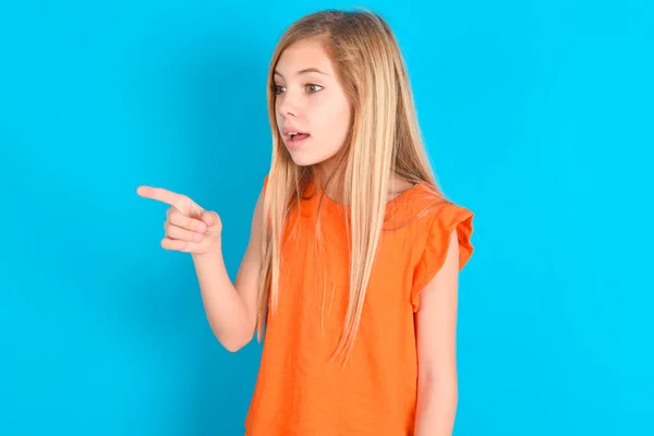 Oszałamiająca Dziewczynka Pomarańczowym Shircie Niebieskim Tle Wielce Zaskoczonym Wyrazem Twarzy — Zdjęcie stockowe