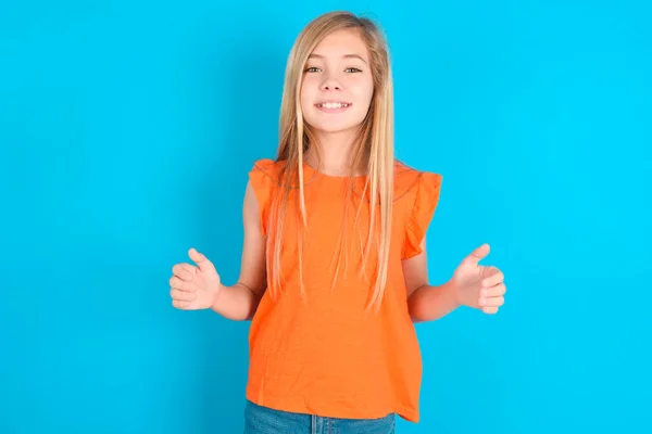 Menina Criança Feliz Vestindo Camiseta Laranja Sobre Fundo Azul Segurando — Fotografia de Stock