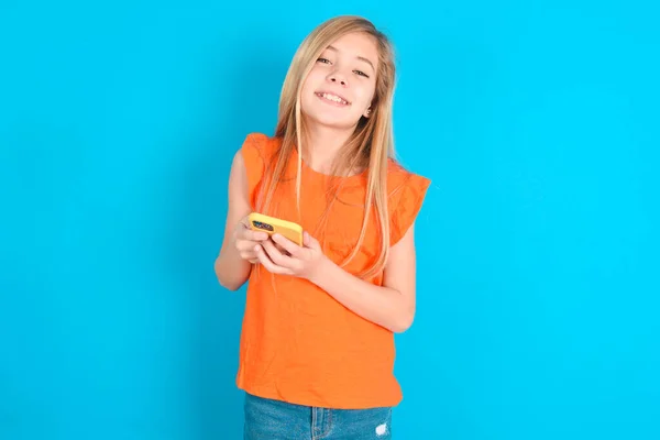 Kleines Mädchen Orangefarbenem Shirt Über Blauem Hintergrund Mit Attrappe Und — Stockfoto