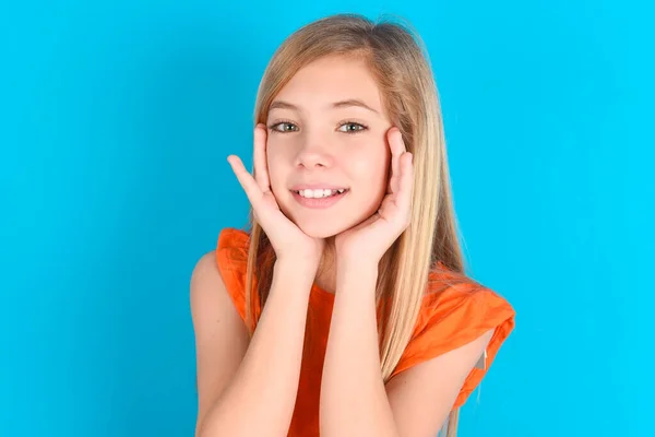 Menina Criança Feliz Vestindo Camiseta Laranja Sobre Fundo Azul Toca — Fotografia de Stock