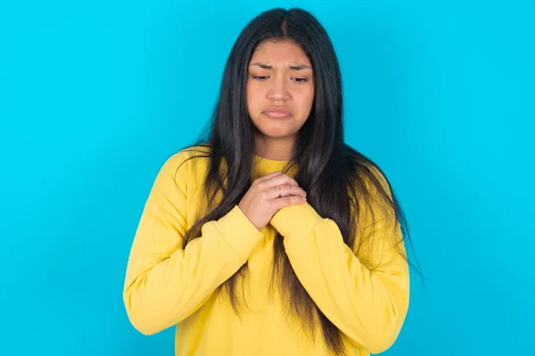 Mujer Latina Triste Usando Sudadera Amarilla Sobre Fondo Azul Sintiéndose —  Fotos de Stock