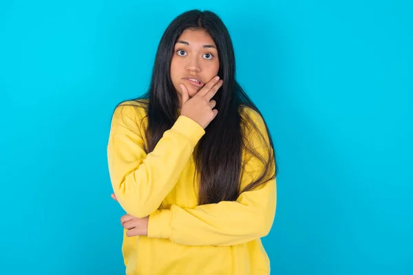 Latin Woman Wearing Yellow Sweatshirt Blue Background Covering Mouth Hands — Stock Photo, Image