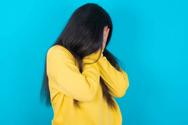 Mulher Latina Triste Vestindo Camisola Amarela Sobre Fundo Azul Cobrindo — Fotografia de Stock