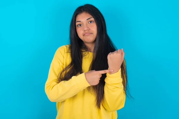 Latijn Vrouw Draagt Geel Sweatshirt Blauwe Achtergrond Haast Wijzend Naar — Stockfoto