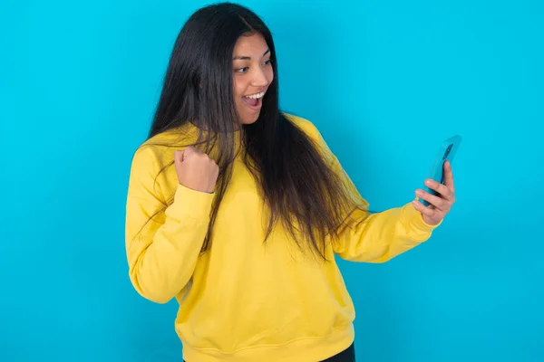 Feliz Mujer Latina Alegre Usando Sudadera Amarilla Sobre Fondo Azul — Foto de Stock
