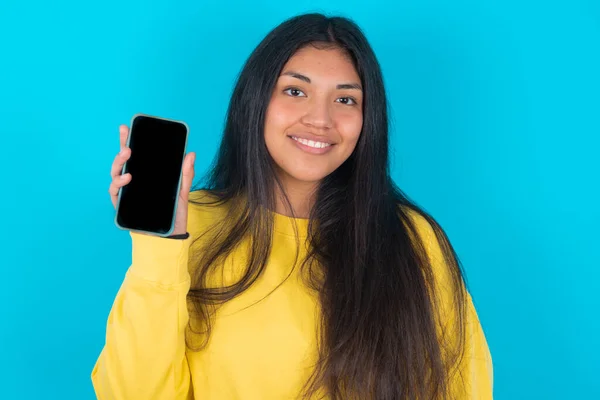 Glimlachende Latijnse Vrouw Met Een Gele Trui Een Blauwe Achtergrond — Stockfoto