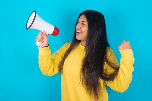 Latijnse Vrouw Draagt Gele Sweatshirt Blauwe Achtergrond Communiceert Schreeuwen Luid — Stockfoto