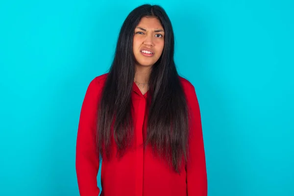 Portrait Dissatisfied Latin Woman Wearing Red Shirt Blue Background Smirks — Stock Photo, Image
