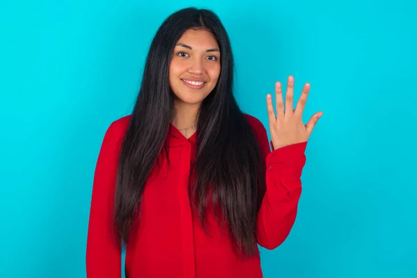 Mujer Latina Vistiendo Camiseta Roja Sobre Fondo Azul Sonriendo Mirando — Foto de Stock