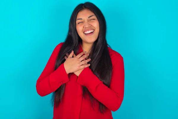 Latynoska Kobieta Czerwonej Koszulce Niebieskim Tle Wyraża Szczęście Śmieje Się — Zdjęcie stockowe