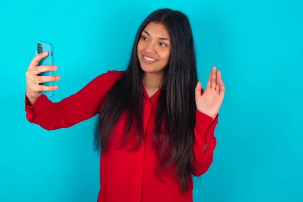 Latinamerikansk Kvinna Bär Röd Shirt Över Blå Bakgrund Håller Modern — Stockfoto