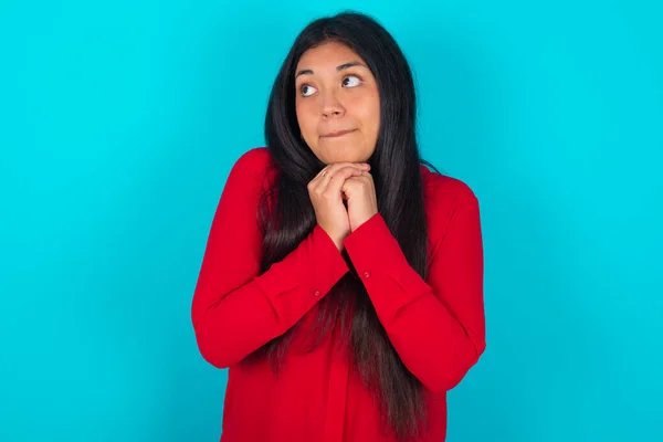 Curiosa Mujer Latina Vistiendo Camiseta Roja Sobre Fondo Azul Mantiene —  Fotos de Stock