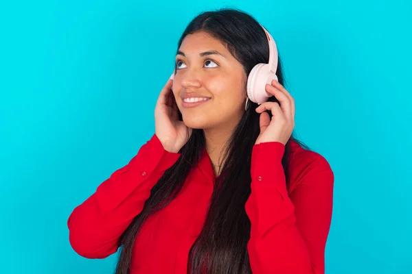 Mujer Latina Con Camiseta Roja Sobre Fondo Azul Lleva Auriculares —  Fotos de Stock