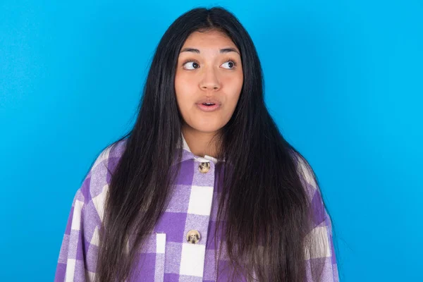 Mulher Latina Chocada Vestindo Camisa Xadrez Sobre Fundo Azul Olhando — Fotografia de Stock