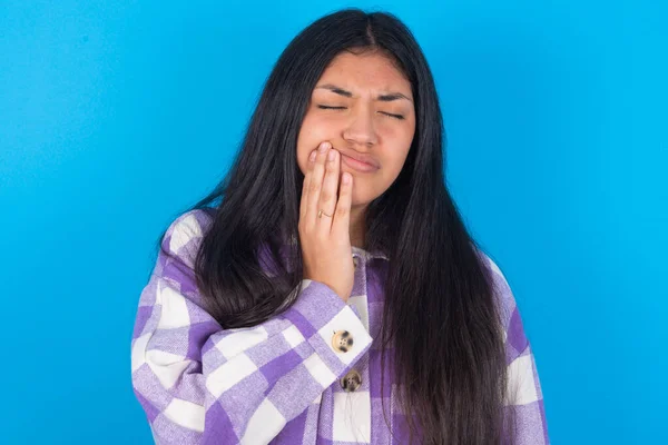 Mavi Arka Planda Ekose Gömlekli Latin Kadın Stüdyoda Diş Ağrısı — Stok fotoğraf