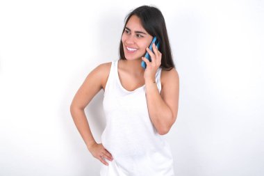 Beyazlar üzerine beyaz bluz giyen güzel esmer kadının, arkadaşıyla cep telefonunda konuşan başarılı bir portresi. Yaşam tarzı ve iletişim konsepti