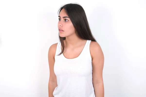 Morena Mujer Vistiendo Top Blanco Sobre Pared Blanca Mira Lado —  Fotos de Stock