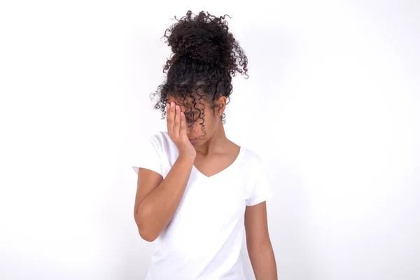 女孩哭的时候 脸上带着忧郁的表情 抑郁症的概念 年轻美丽的混血女子 身穿白色T恤衫 站在白墙外 — 图库照片