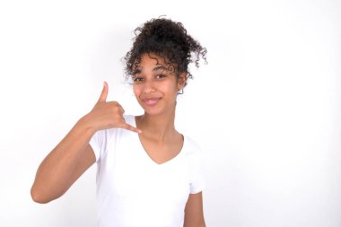 Kız telefon eder, beni tekrar ara der, mutlu bir ifadesi vardır. Beyaz tişört giyen, beyaz duvarın üzerinde poz veren güzel, melez bir kadın.