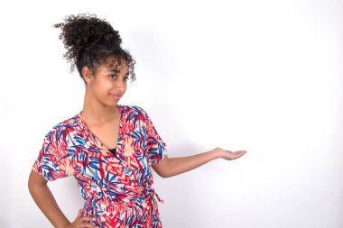 Hoş bir jest olarak beyaz duvarın üzerinden renkli elbiseler giyen genç ve güzel bir kadının portresi..