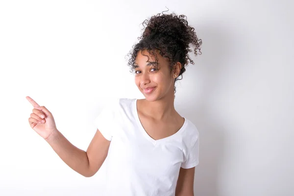 女孩站在空白处演示广告 人与晋升概念 年轻美丽的混血女子 身穿白色T恤衫 站在白墙外 — 图库照片