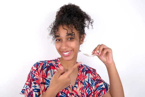 Mujer Morena Vistiendo Vestido Colorido Sobre Pared Blanca Sosteniendo Alineador — Foto de Stock