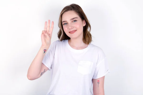 Młoda Kaukaska Kobieta Białej Koszulce Białym Tle Pokazuje Wskazując Palcami — Zdjęcie stockowe