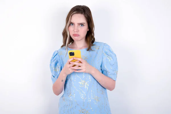 Πορτρέτο Ενός Συγκεχυμένου Κοριτσιού Που Κρατάει Κινητό Τηλέφωνο Και Σπρώχνει — Φωτογραφία Αρχείου