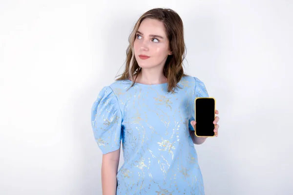 배경에 파란색 티셔츠를 코카서스 새로운 전화를 옆으로 보이는 셀룰러의 화면을 — 스톡 사진