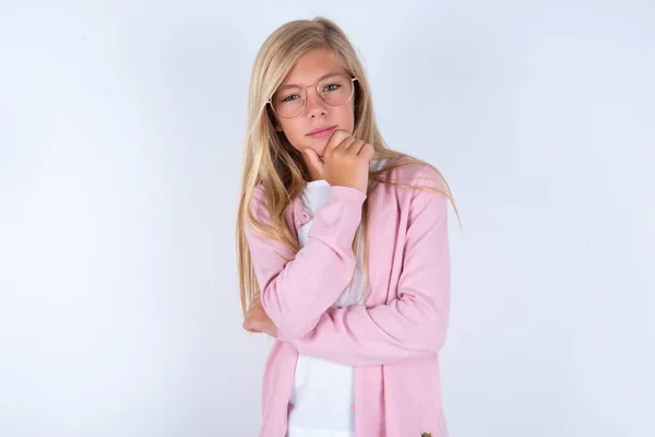 Blond Meisje Dragen Roze Jas Bril Witte Achtergrond Ding Kijken — Stockfoto