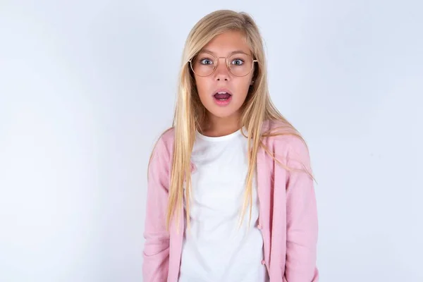 Blondýnka Holčička Růžové Bundě Brýle Nad Bílým Pozadím Zírá Kameru — Stock fotografie