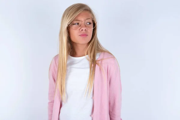 Blond Meisje Dragen Roze Jas Bril Witte Achtergrond Kijken Opzij — Stockfoto