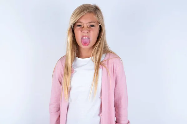 Блондинка Маленькая Девочка Розовой Куртке Очках Белом Фоне Смешное Лицо — стоковое фото