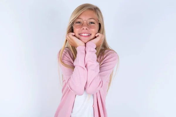 Beyaz Arka Planda Pembe Ceketli Gözlüklü Küçük Sarışın Kız Ellerini — Stok fotoğraf