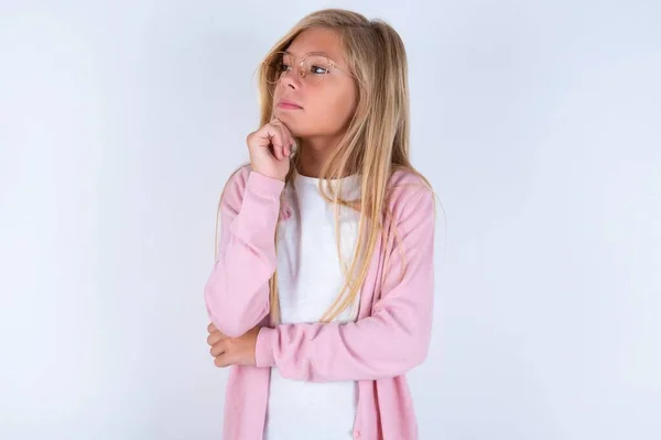 Blond Klein Meisje Draagt Roze Jas Bril Witte Achtergrond Houdt — Stockfoto