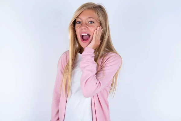 Маленькая Блондинка Розовой Куртке Очках Белом Фоне Чувствует Себя Счастливой — стоковое фото