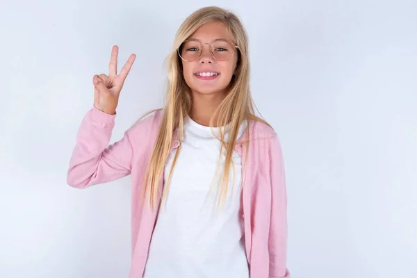 Niña Rubia Vistiendo Chaqueta Rosa Gafas Sobre Fondo Blanco Mostrando —  Fotos de Stock