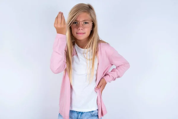 ブロンドの少女はイタリアのジェスチャーをする上げられた手で身に着けている白い背景のジェスチャーの上にピンクのジャケットとメガネを着ています — ストック写真