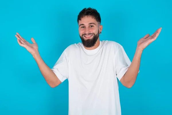 Homem Caucasiano Barbudo Vestindo Camiseta Branca Sobre Fundo Azul Levantando — Fotografia de Stock