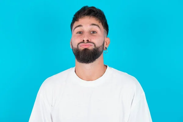 Homem Caucasiano Barbudo Vestindo Shirt Branca Sobre Fundo Azul Mantém — Fotografia de Stock