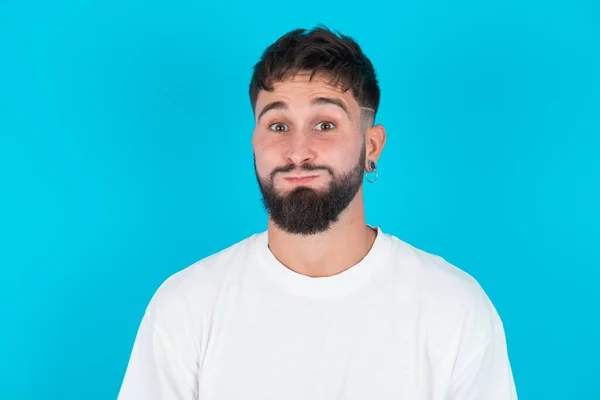 Barbudo Caucasiano Homem Vestindo Branco Shirt Sobre Azul Fundo Soprando — Fotografia de Stock