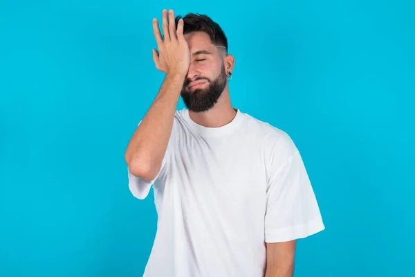 Frustrado Hombre Caucásico Barbudo Vistiendo Camiseta Blanca Sobre Fondo Azul —  Fotos de Stock