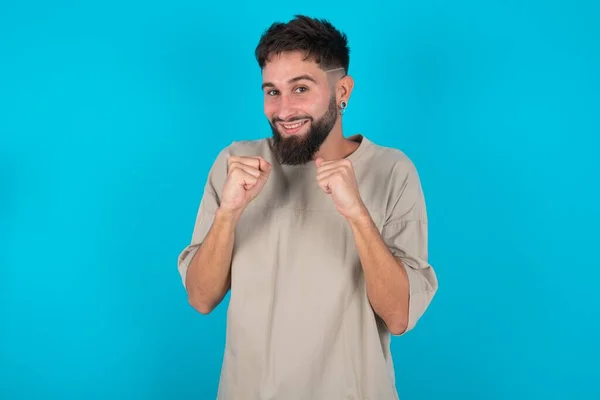 Barbudo Hombre Caucásico Vistiendo Casual Camiseta Sobre Fondo Azul Aprieta —  Fotos de Stock